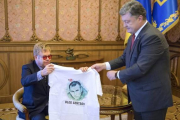 El presidente ucraniano, Petro Poroshenko, entrega una camiseta con la imagen de un cineasta encarcelado en Rusia al cantante Elton John.-EFE / MIKHAIL PALINCHAK