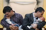 Dos padres acunan a sus bebés.-MIGUEL LORENZO