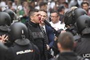 Un hincha polaco con la cara ensangrentada se enfrenta a los antidisturbios, esta tarde junto al Bernabéu.-EFE