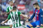 Piqué, junto a Cejudo, en el Barça-Betis de la primera jornada.-JORDI COTRINA