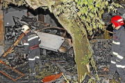 Dos bomberos entre los restos calcinados de los dos vehículos implicados en el suceso en el que fallecieron dos personas. / EFE-