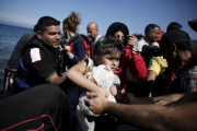Una niña siria es ayudada a bajar de su embarcación en la isla griega de Lesbos, este sábado.-LKIS KONSTANTINIDIS