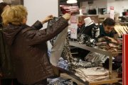 Una mujer observa una camiseta rebajada en Madrid.-Foto: EFE