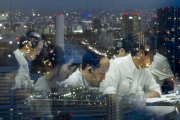Empleados japoneses trabajando a altas horas de la noche en una empresa tecnológica con sede en Tokio.-THOMAS PETER (REUTERS)