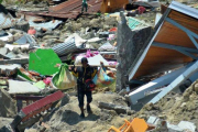 Un hombre carga objetos personales entre los escombros de un edificio derrumbado por el terremoto, en la ciudad indonesia de Palu.-RIFKI (AP)