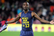 El defensa francés del FC Barcelona Eric Abidal muestra una camiseta de agradecimiento a su primo, donante de su trasplante, durante un partido en 2013.-TONI ALBIR