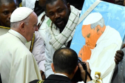 Un inmigrante muestra al Papa el retrato que le ha hecho, durante la audiencia general de los miércoles en el Vaticano-ETTORE FERRARI