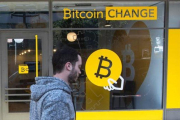 Un ciudadano israelí pasa delante de una oficina de cambio de bitcoines, en Tel-Aviv.-AFP/JACK GUEZ