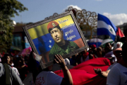 Miembros de la Juventud Sandinista y trabajadores del Estado participaron en una caminata con banderas de Venezuela y cuadros con el rostro de Chávez.-EFE