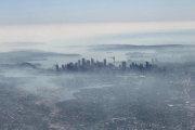 Imagen aérea de la ciudad de Sídney cubierta por una densa nube de humo blanco, este martes.-NEIL BENNETT (DPA)