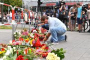 Un hombre deposita flores junto al lugar del ataque.-AFP