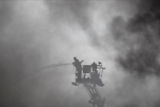 Un bombero trabaja en el lugar del incendio, una fábrica de embalajes de cuatro plantas.-AP