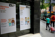 Oficina de una entidad bancaria con publicidad sobre hipotecas.-FERRAN NADEU