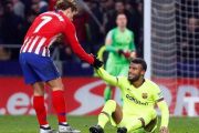 Griezmann ayuda a Rafinha a levantarse en la segunda parte del Atlético-Barça en el Metropolitano.-REUTERS / PAUL HANNA