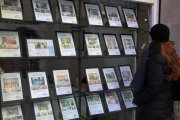 Una mujer consulta precios de pisos en una inmobiliaria.-RICARD CUGAT