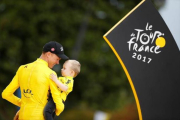 Chris Froome, el ciclista británico, sostiene en brazos a Kellan, su hijo, en el podio de París.-REUTERS / CHRISTIAN HARTMANN