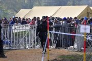 Refugiados controlados por agentes de policía en el saturado centro de acogida de Brezice, este miércoles.-EFE / IGOR KUPLJENIK