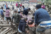 Vecinos de Mocoa ayudan a evacuar a una mujer herida por la avalancha.-AGENCIA