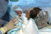 Un bebé y su madre, en el hospital.-