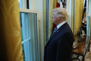 Trump mira por una ventana del Despacho Oval durante la entrevista con motivo de sus 100 días en la Casa Blanca.-CARLOS BARRIA