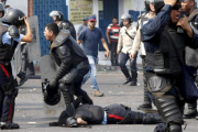 Uno de los policías yace en el suelo justo después de ser arrollado por le autobús.-REUTERS / CARLOS EDUARDO RAMIREZ