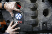 Un trabajador muestra el logo de un motor diésel TDI de Volkswagen de segunda mano en Jelah, Bosnia.-REUTERS/DADO RUVIK