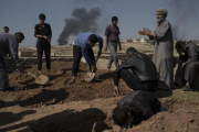 Unos civiles entierran cadáveres en el lado occidental de Mosul.-AP