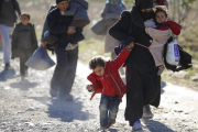 Una familia de refugiados se dirige a la frontera de Macedonia con Serbia.-