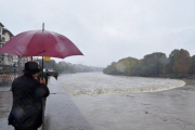 Varias personas observan la crecida del río Po durante unas fuertes lluvias en Turín. Cerca de once regiones italianas se encuentran en estado de emergencia debido a las lluvias y tormentas de los últimos días.-EPA/ANSA
