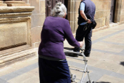 Una mujer se ayuda de un andador para caminar por la calle. / VALENTÍN GUISANDE-