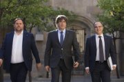El president Carles Puigdemont, entre el vicepresidente Oriol Junqueras y el consejero Jordi Turull, en el Palau de la Generalitat.-ALBERT BERTRAN