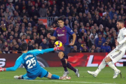 Suárez pica el balón ante Courtois en una imagen de archivo.-ENRIC FONTCUBERTA (EFE)
