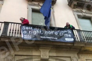 Los manifestantes de la ANC han subido mediante una escalera al balcón de la sede de la Comisión Europea, en Barcelona.-JÚLIA REGUÉ