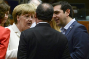 El primer ministro griego, Alexis Tsipras (dcha) habla con la canciller alemana Angela Merkel (izda) y el presidente francés François Hollande (c) durante la reunión del Eurogrupo en Bruselas.-Foto: EFE