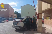 Agentes de la Guardia Civil meten al detenido en el coche oficial.