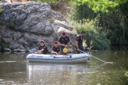 Policías del grupo de actividades acuáticas sondeando el río.