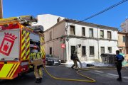 Los bomberos refrescan la zona tras apagar dos contenedores ardiendo en el barrio del Calaverón en la tarde del jueves festivo.