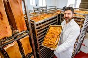 Pablo Romero posa entre pancetas frescas y torreznos recién prefritos en la fábrica.