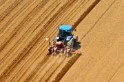 Un agricultor ara un campo de cultivo con su tractor para proceder a la sementera.