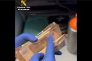 Un agente de la Guardia Civil recuenta un fajo de billetes en un registro.