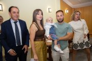 Un pequeño en brazos de sus padres tras la imposición del pañuelo.