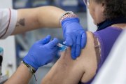 Archivo - Una mujer se vacuna durante la campaña de vacunación contra la gripe.