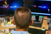 Un agente de la Guardia Civil de Tráfico vigila la circulación en unas pantallas.