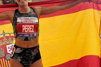 Marta Pérez posa con la bandera de España tras batir el récord de España de la Milla en Nueva.