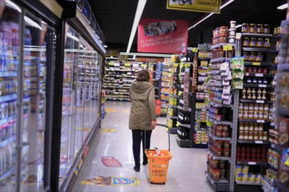 Una clienta deambula entre los estantes llenos de productos de un supermercado .-EL PERIÓDICO