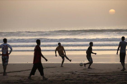 Jóvenes marroquíes jugando a fútbol en la playa de Agadir, al sur del país.-CRISTOPHE ENA (AP)