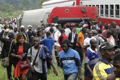 Pasajeros del tren descarrilado salen del lugar del accidente.-AFP