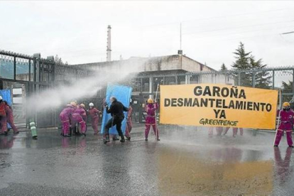 Miembros de Greenpeace reciben manguerazos para evitar su acceso a la central, durante una protesta en Garoña.-GREENPEACE / GREENPEACE