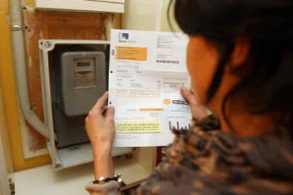 Una mujer consulta la factura de la luz.-DANNY CAMINAL