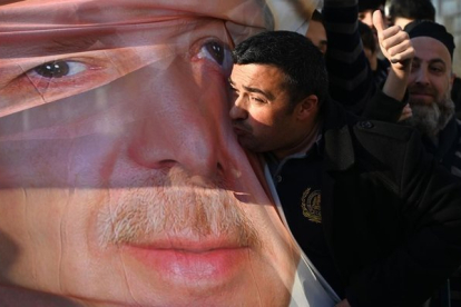 Un simpatizante de Erdogan besa una foto con la imagen del mandatario turco, en Estambul.-OZAN KOSE (AFP)